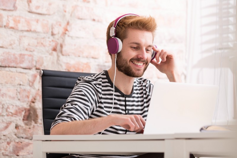 Jeune professionnel souriant travaillant sur ordinateur dans un bureau