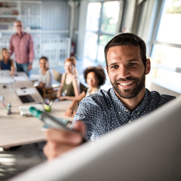 Formateur souriant animant une session de formation en présentiel