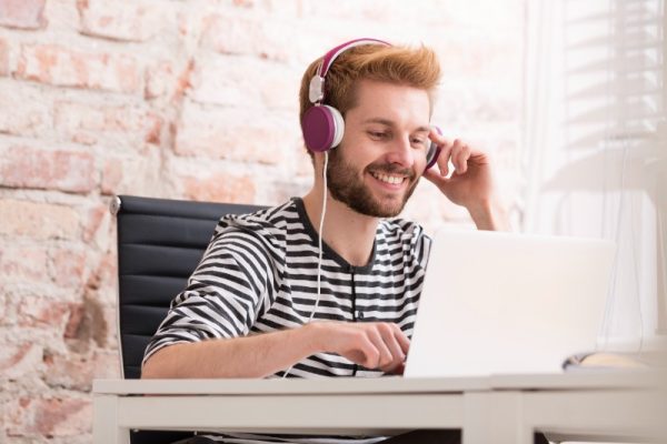 Jeune professionnel souriant travaillant sur ordinateur dans un bureau